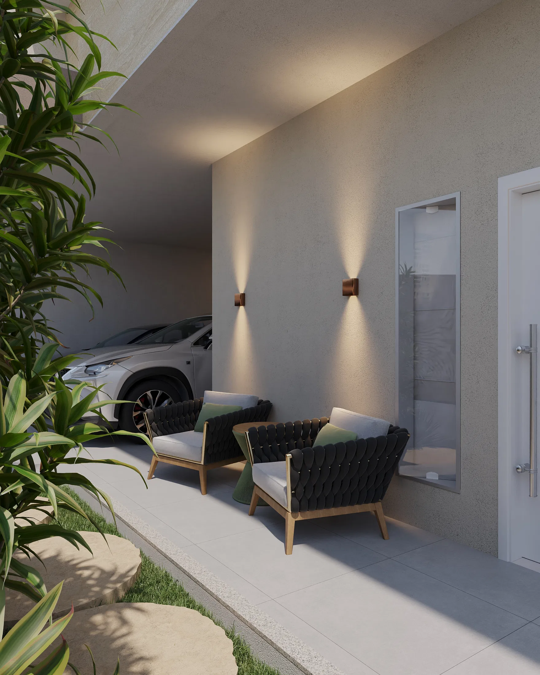 Vista lateral da área de estar externa com poltronas pretas trançadas, luminárias de parede acesas e portão de vidro junto à garagem