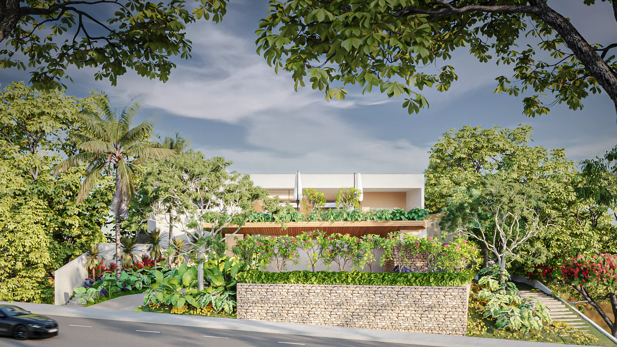 Fachada vista da rua, parcialmente encoberta por árvores e muro de pedra com jardineiras floridas na cobertura