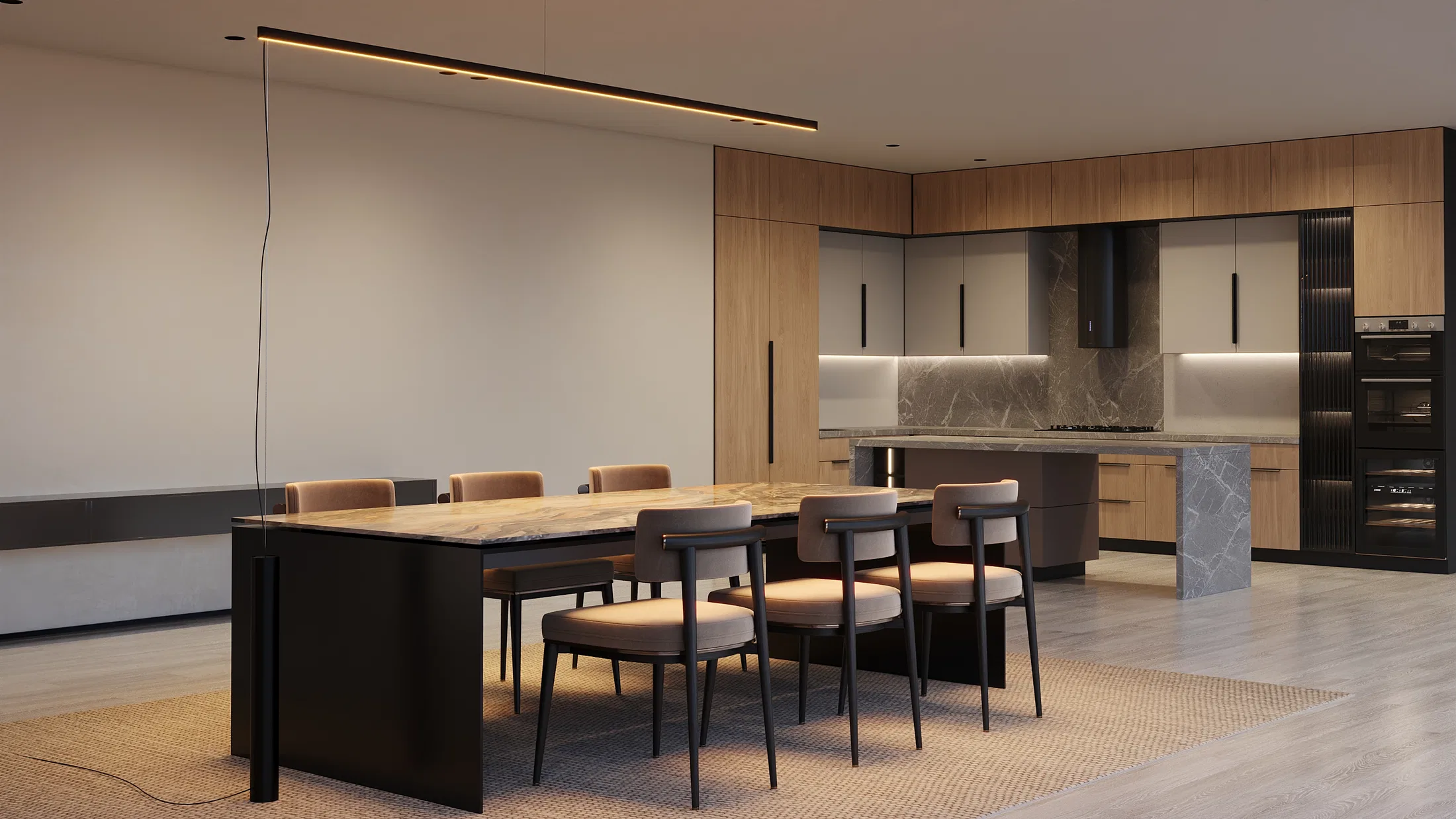 Cozinha integrada com marcenaria em madeira e ilha de mármore ao fundo, mesa de jantar em pedra com cadeiras estofadas e luminária linear suspensa acesa.