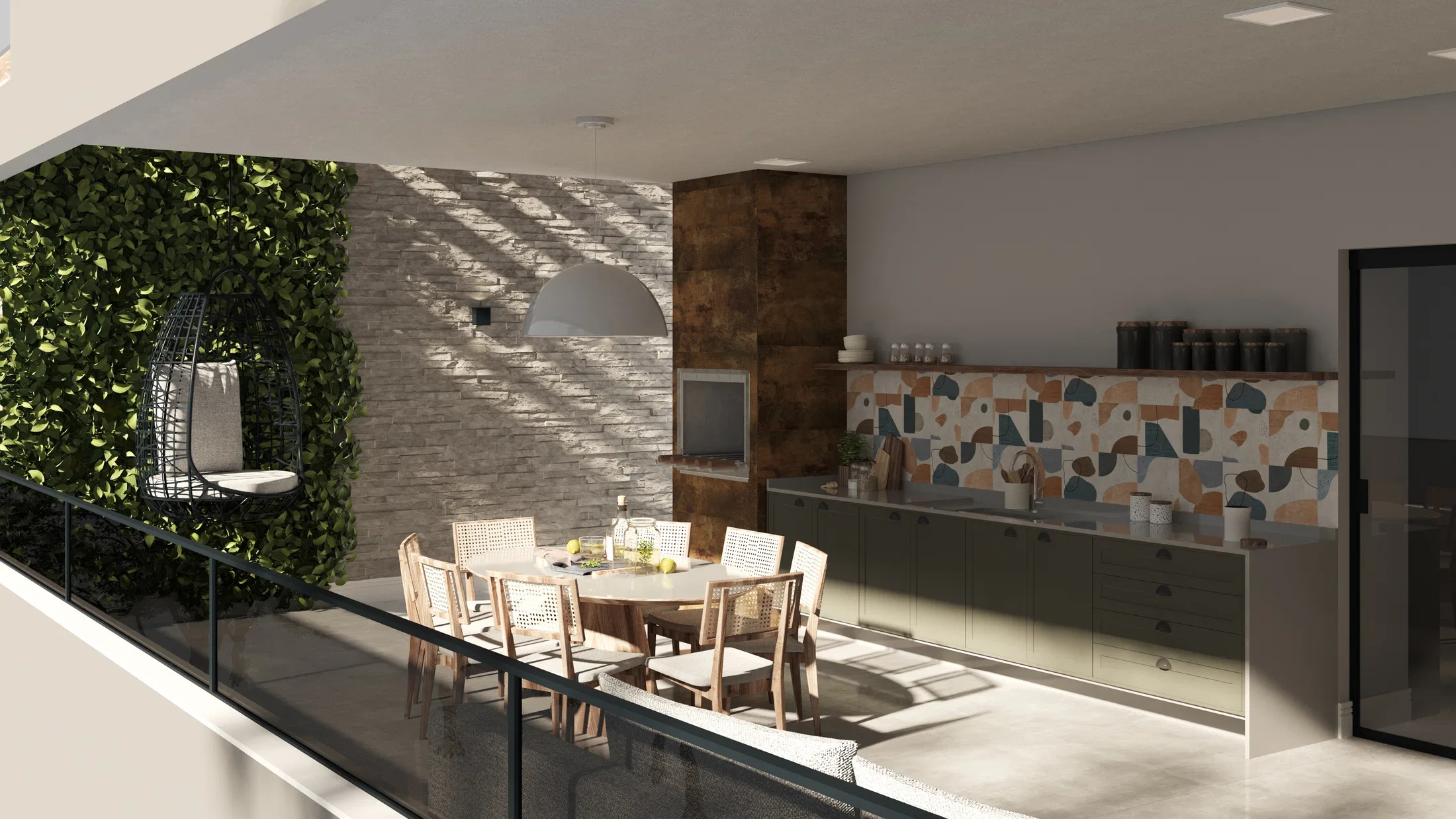 Varanda gourmet com sofá em primeiro plano, mesa de jantar redonda, parede de pedra e vista para árvores ao fundo