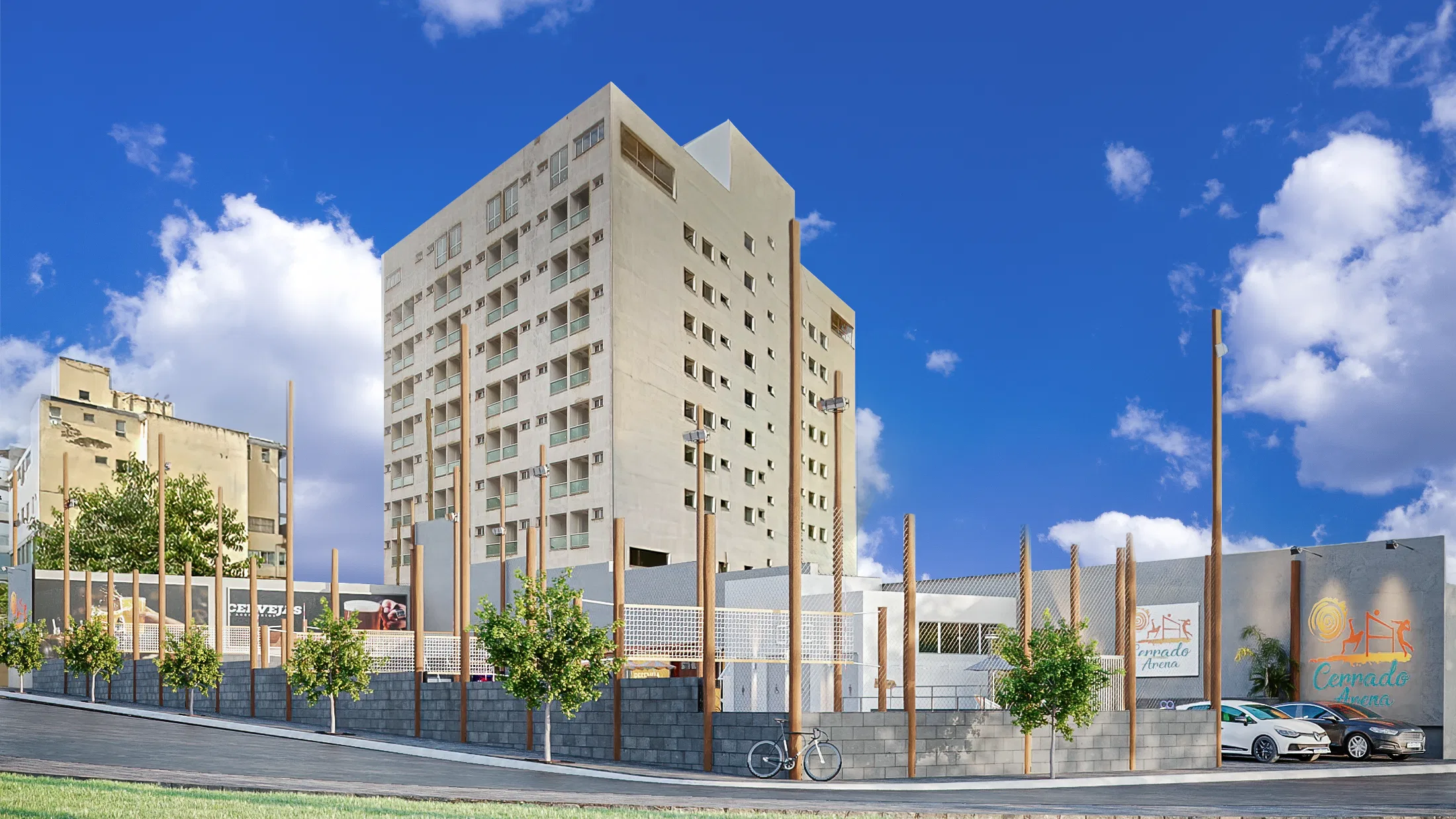 Vista de rua do complexo, com muro de blocos e postes verticais de madeira, árvores, bicicleta e carros estacionados diante de uma torre residencial