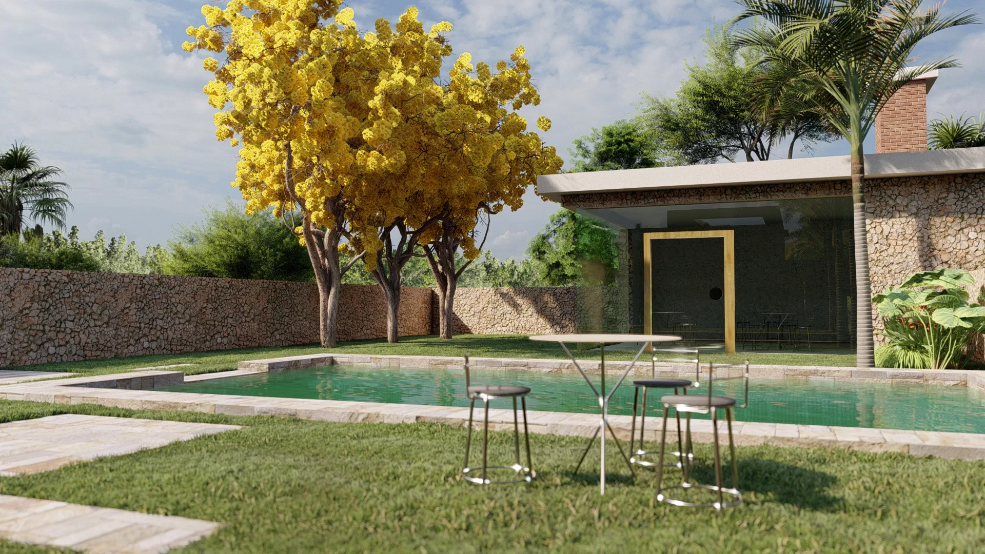 Piscina com muro de pedra e árvores de floração amarela ao fundo, mesas altas com banquetas sobre o gramado