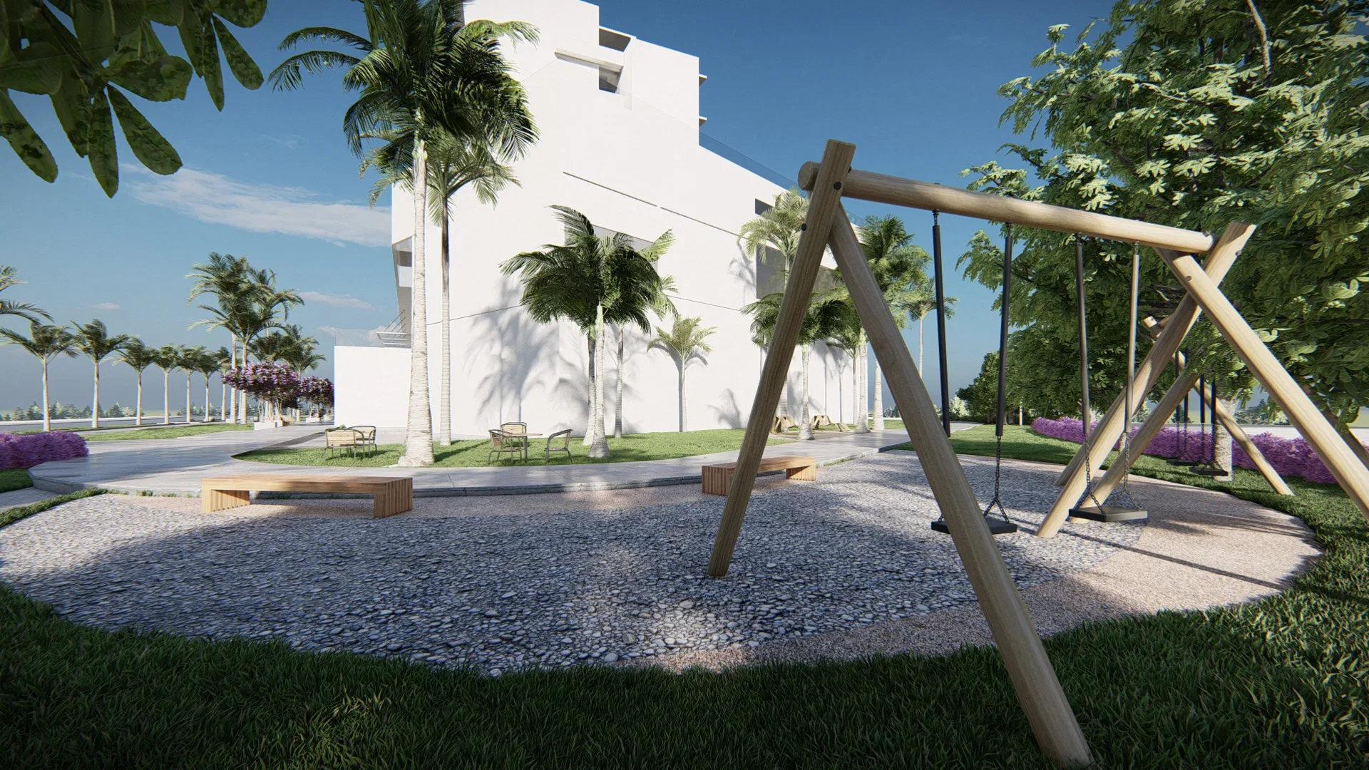 Playground com balanço de madeira sobre piso de seixos, ladeado por bancos e coqueiros, com o edifício branco ao fundo.