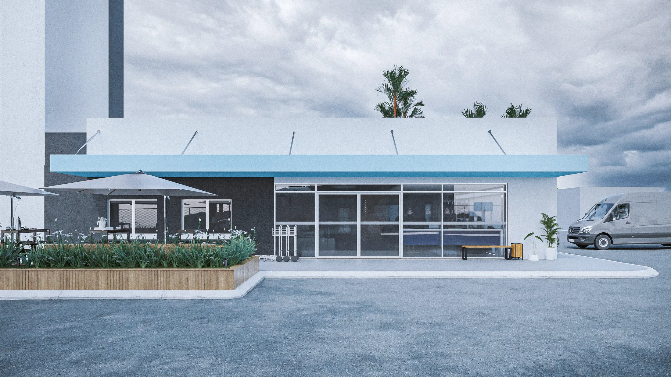 Elevação frontal do pavilhão de café envidraçado com toldo azul e terraço de guarda-sóis atrás de um canteiro de gramíneas, em dia nublado