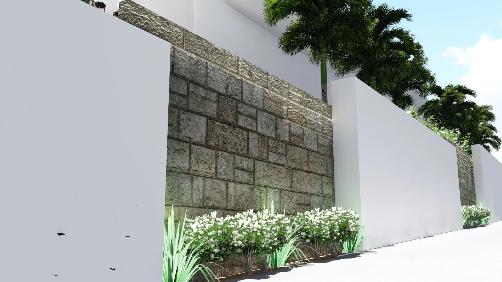 Muro de pedra aparelhada com maciço de flores brancas e touceiras na base, palmeiras despontando atrás das paredes claras