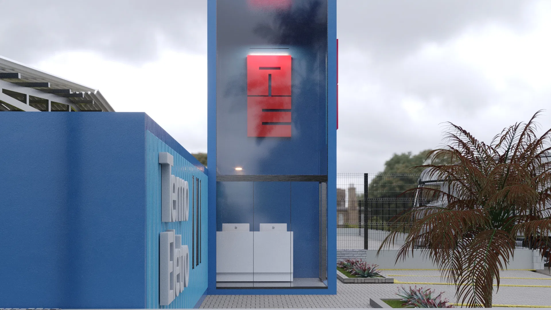 Close da torre de vidro com o monograma vermelho retroiluminado refletindo o céu nublado, equipamentos brancos visíveis no térreo e palmeira seca à direita