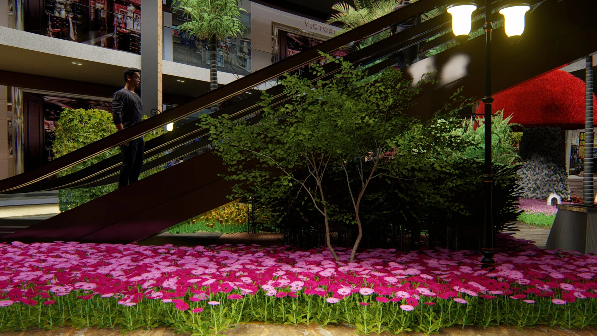 Denso tapete de margaridas magenta sob as escadas rolantes, com pequena árvore ornamental, poste clássico preto e vitrines iluminadas ao fundo