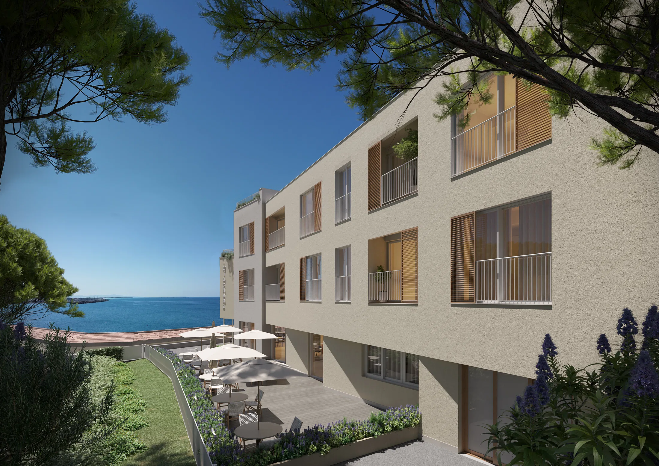 Fachada lateral com janelas e venezianas de madeira sobre terraço com guarda-sóis, canteiros de lavanda e vista para o mar