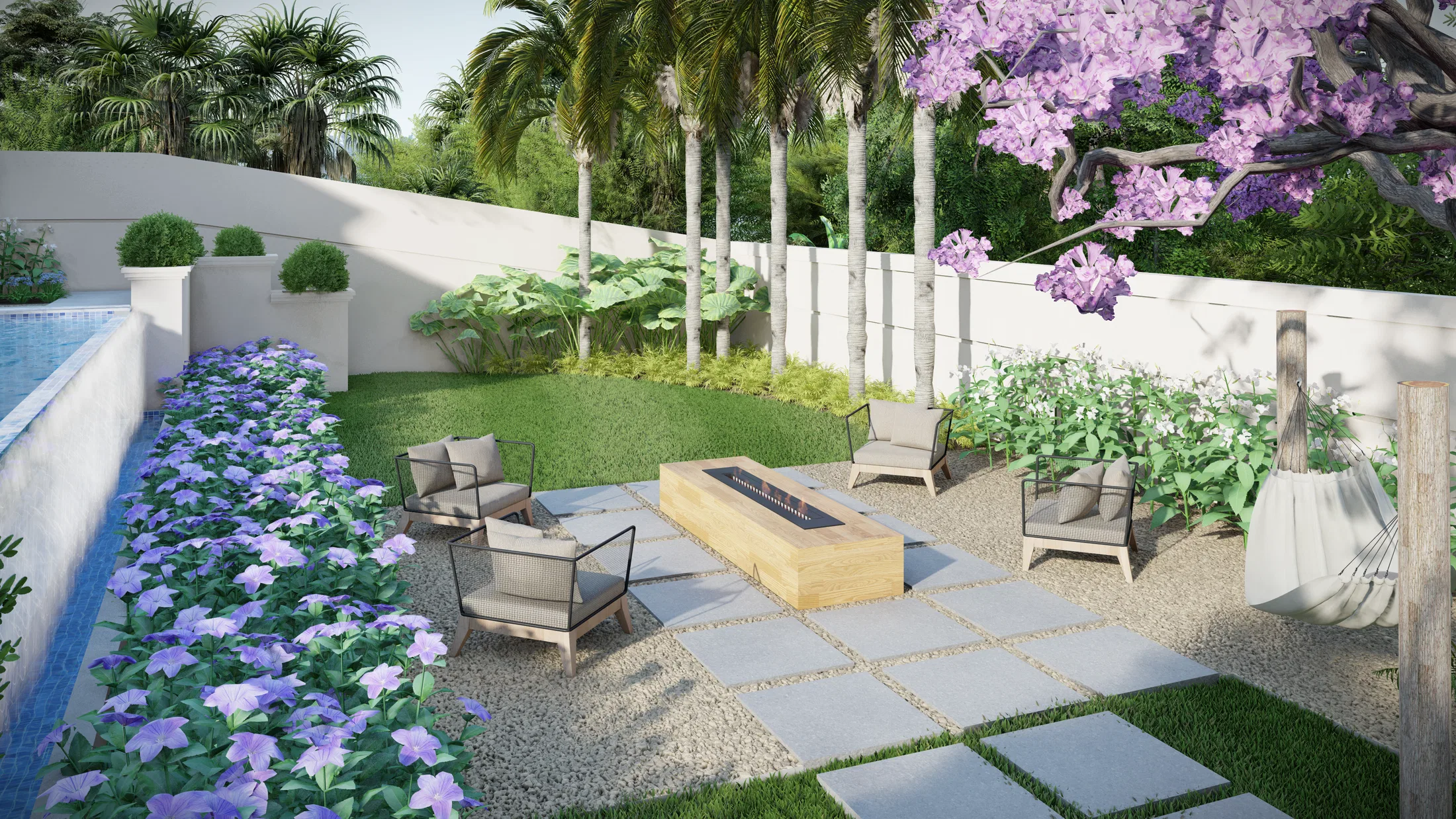 Estar externo com fogueira linear de madeira, poltronas de vime sobre pedra e brita, palmeiras e canteiro de flores azuis à beira da piscina