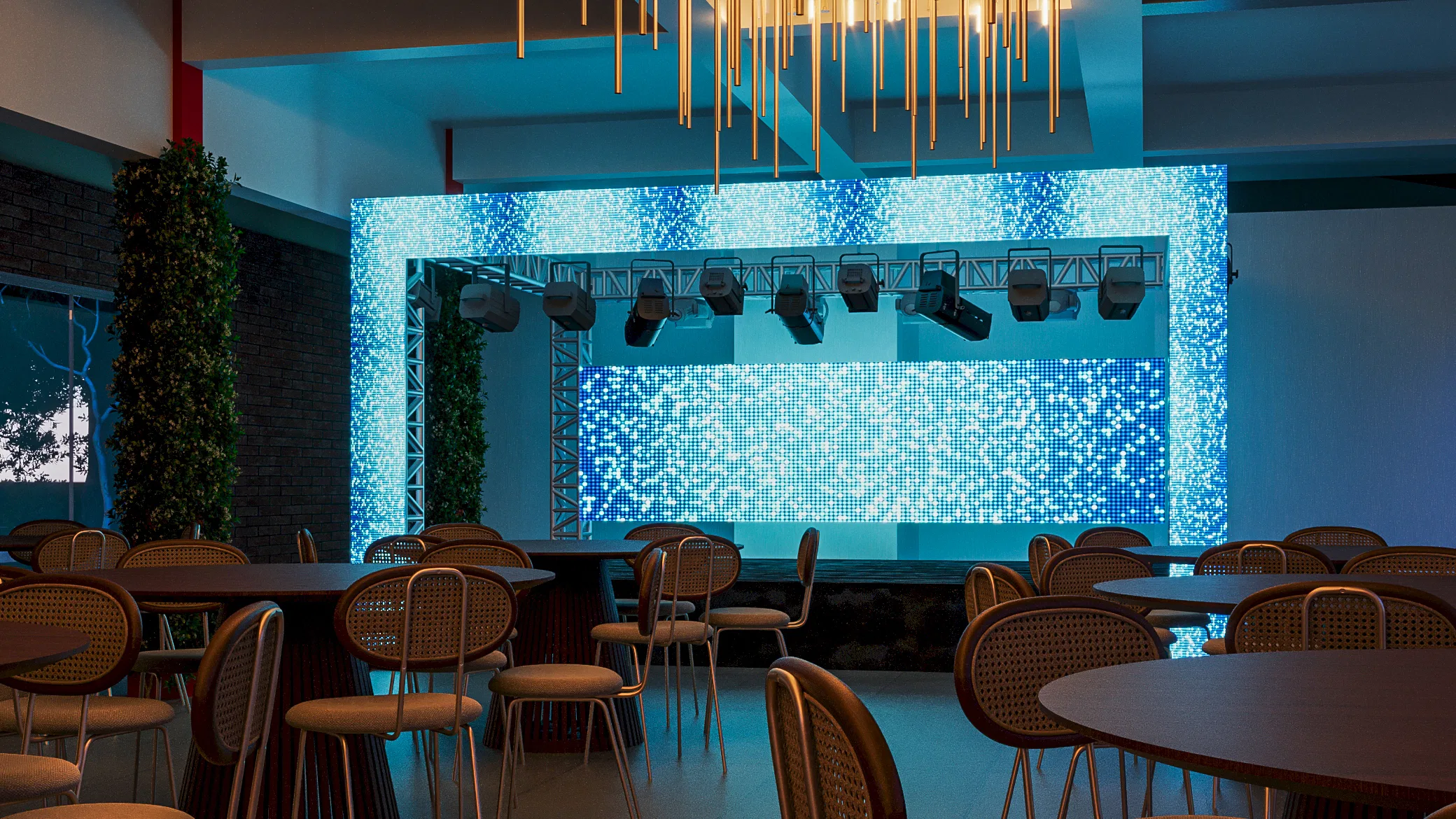 Salão de eventos com painel de LED azul cintilante e refletores em treliça, mesas redondas com cadeiras de palhinha sob lustre de hastes douradas