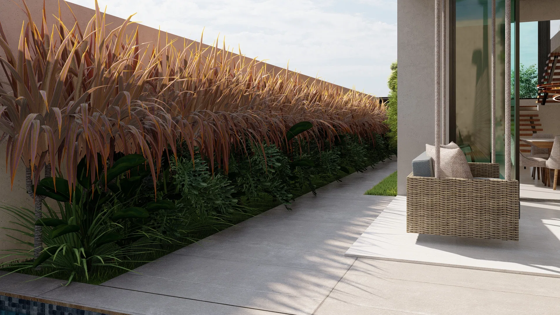 Pátio lateral com canteiro de gramíneas avermelhadas e samambaias ao longo do muro, terraço pavimentado amplo e poltrona de vime diante do vidro da sala