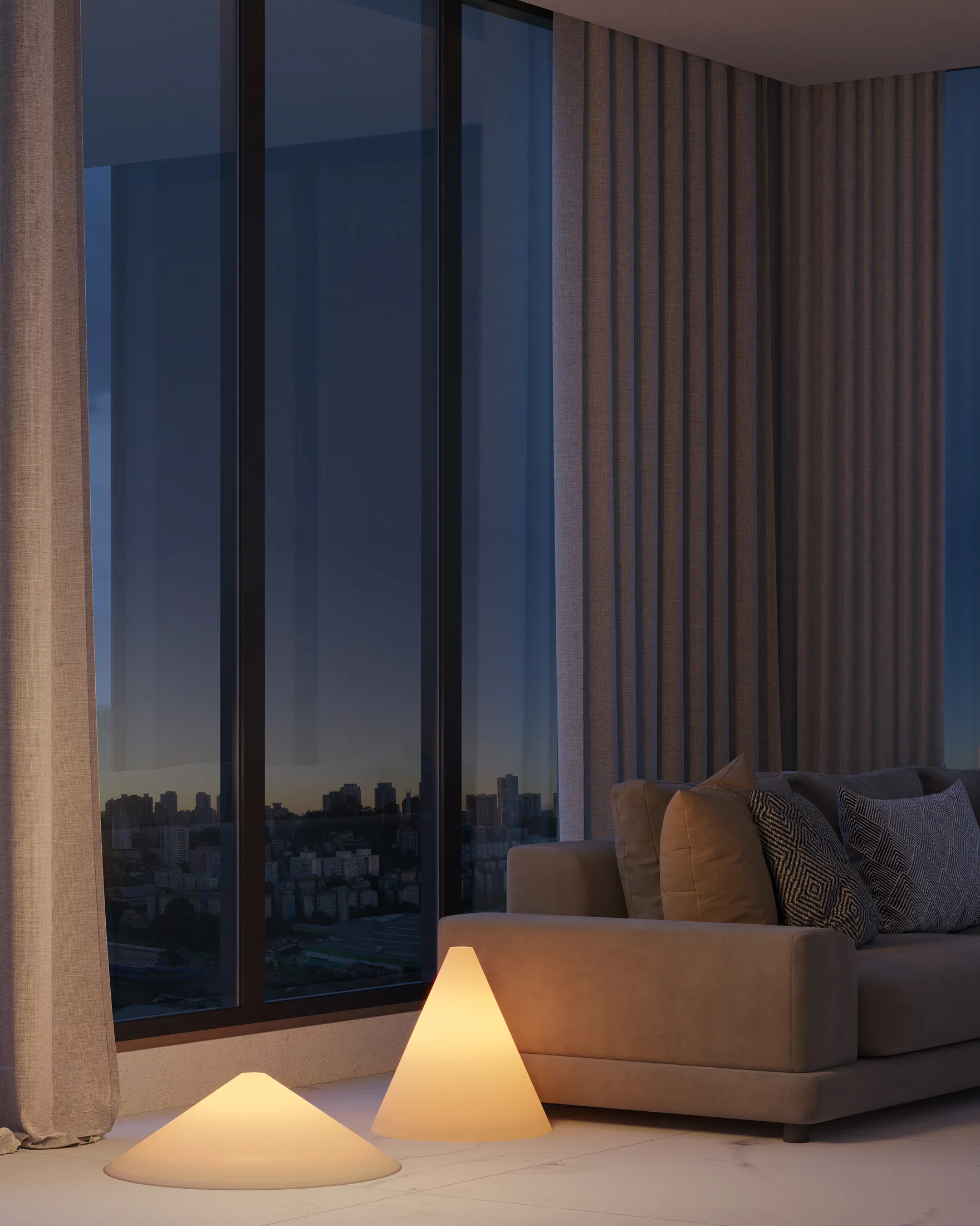 Duas luminárias cônicas usadas como luminárias de piso junto à janela de uma sala ao anoitecer, com sofá bege e luzes da cidade