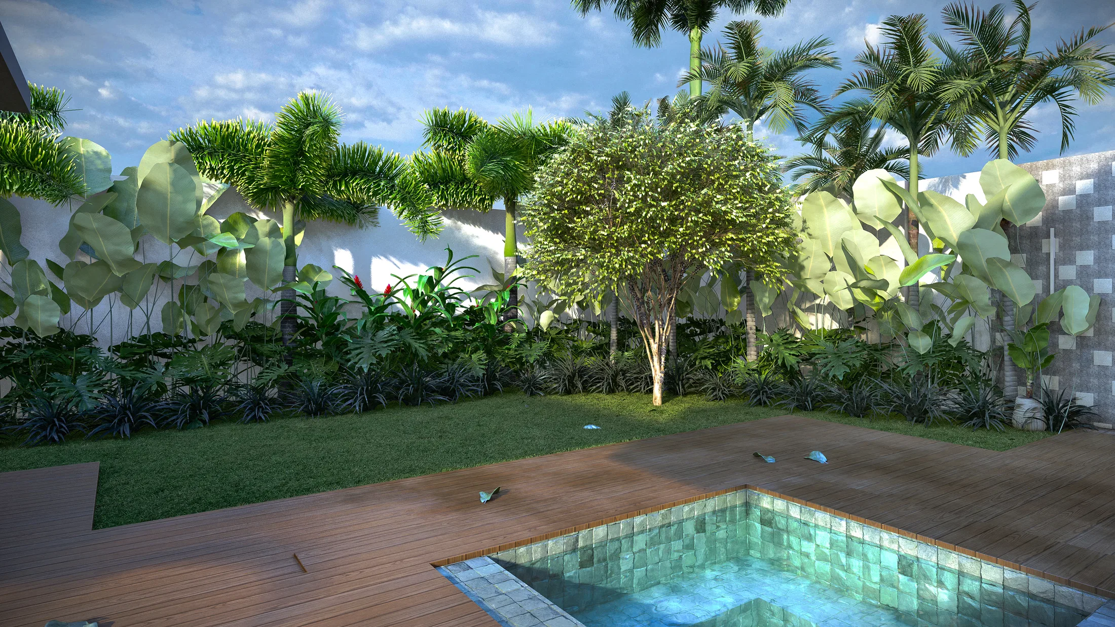 Área de piscina revestida em pastilha esverdeada com deck de madeira, faixa de grama e árvore central diante de plantio tropical denso junto ao muro branco