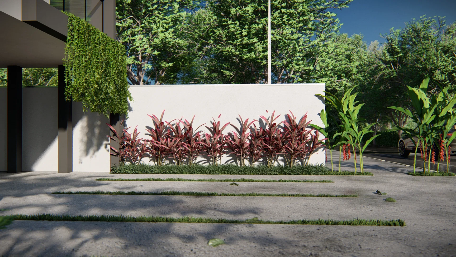 Canteiro linear com fileiras de folhagem vermelha junto a um muro branco, ladeado por faixas de grama na calçada e helicônias laranja
