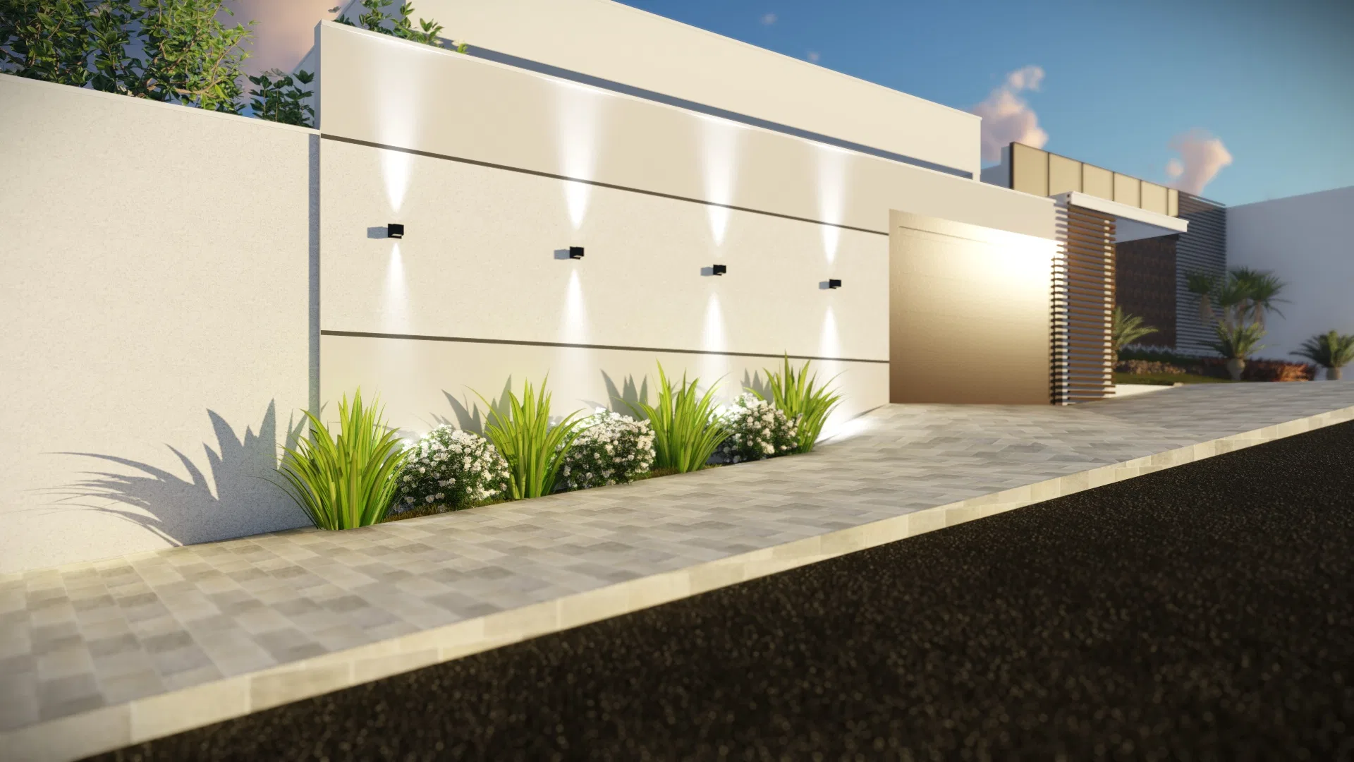 Muro branco com luminárias embutidas iluminando canteiro de gramíneas e flores brancas, junto ao portão de acesso e à calçada de intertravado