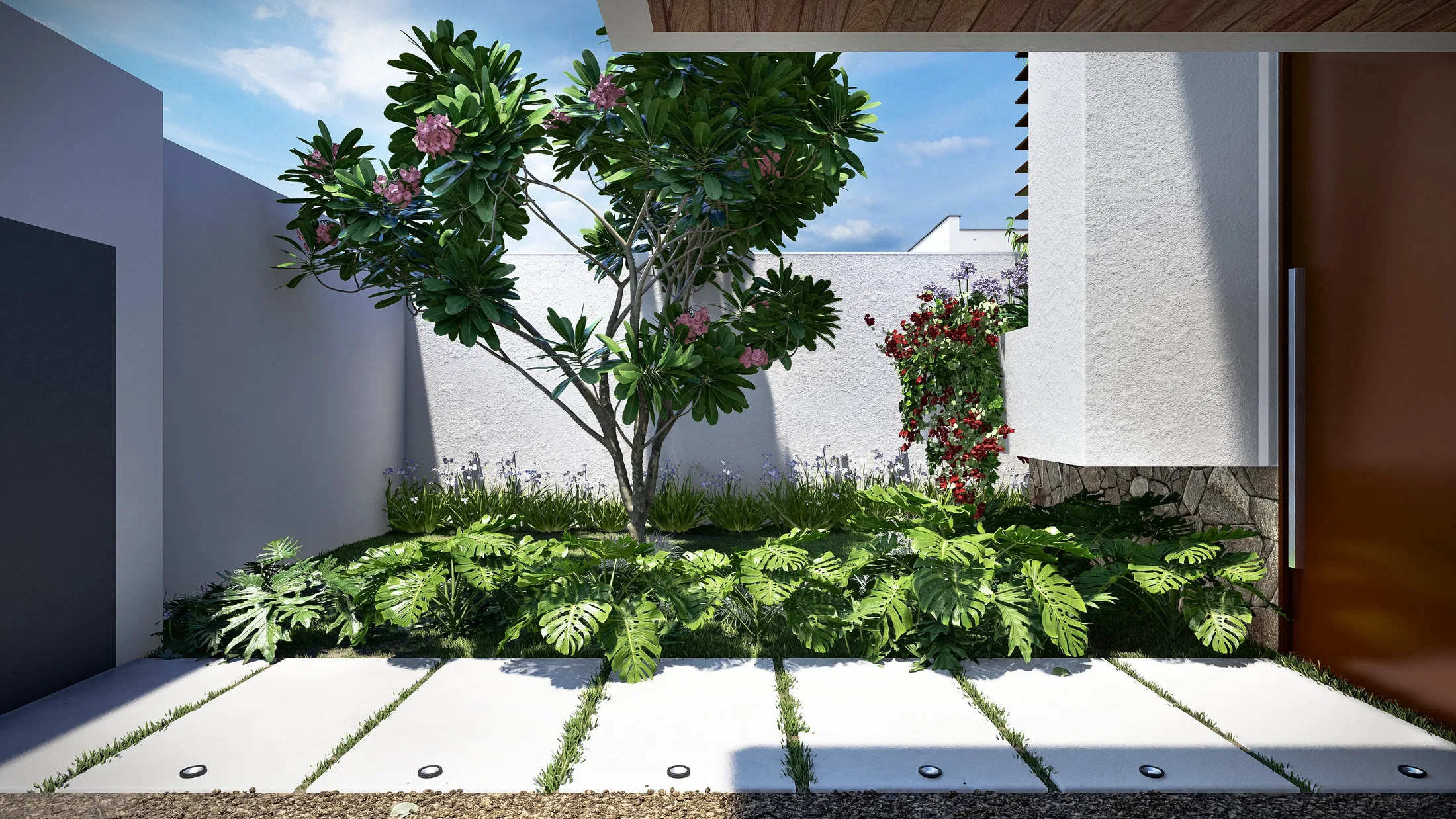 Pátio de entrada com árvore de flores rosadas contra muro branco, forração de folhas recortadas e grandes placas de piso com juntas de grama