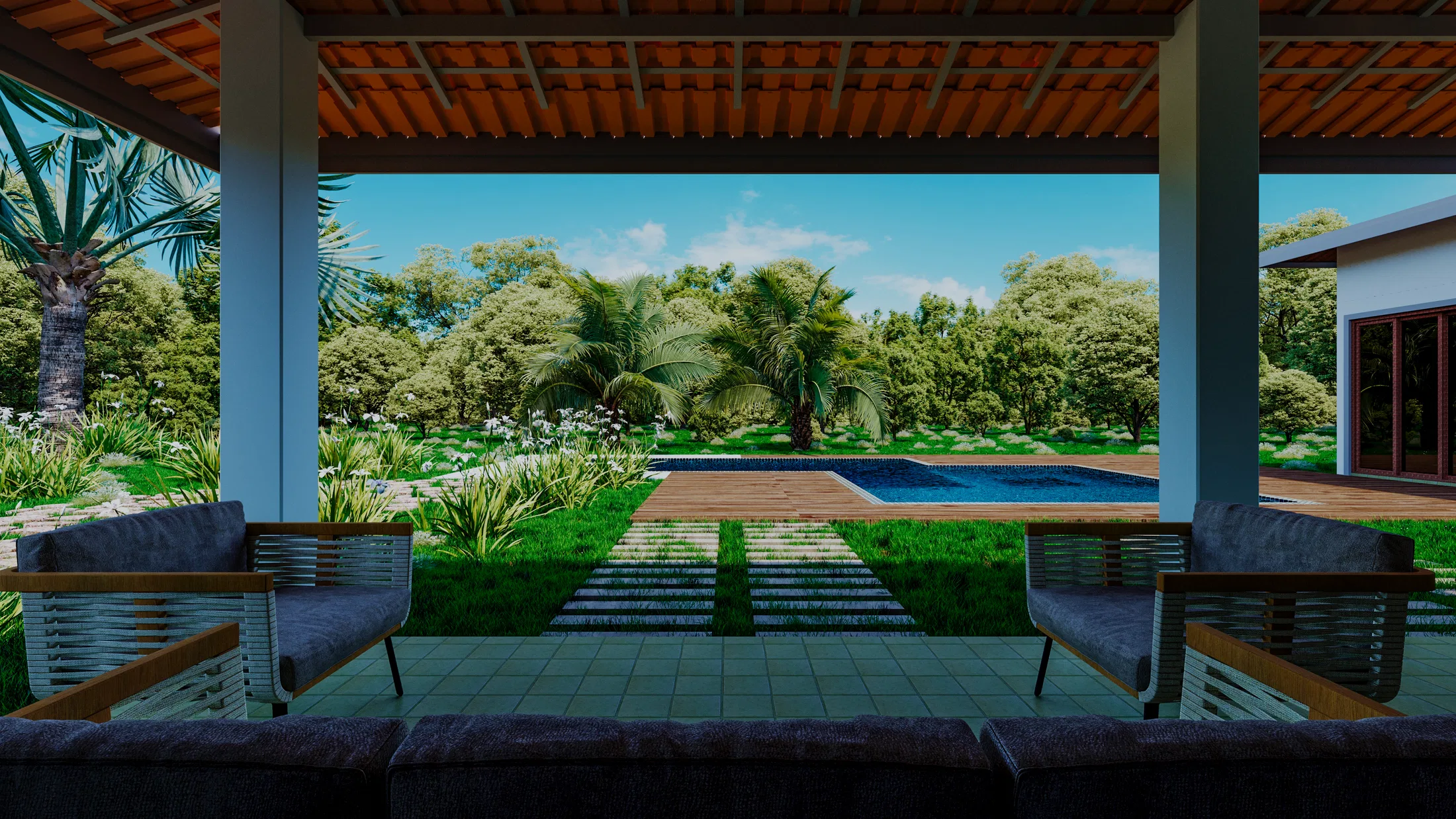 Vista da piscina emoldurada por vegetação densa, a partir de um deck coberto com sofás de estar.