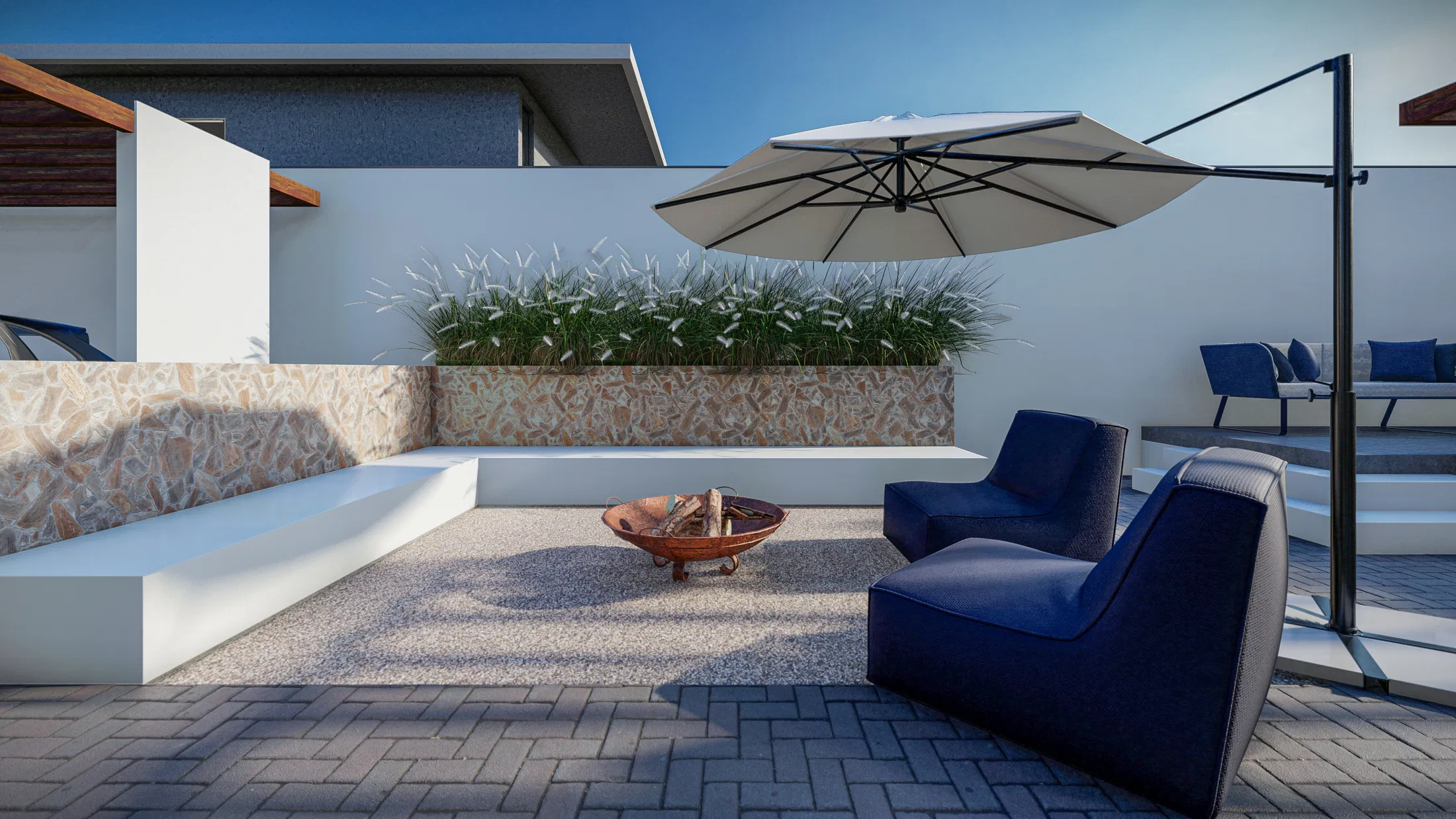 Terraço coberto com banco de alvenaria, jardineira de plantas ornamentais, bacia de fogo e poltronas azuis sob guarda-sol
