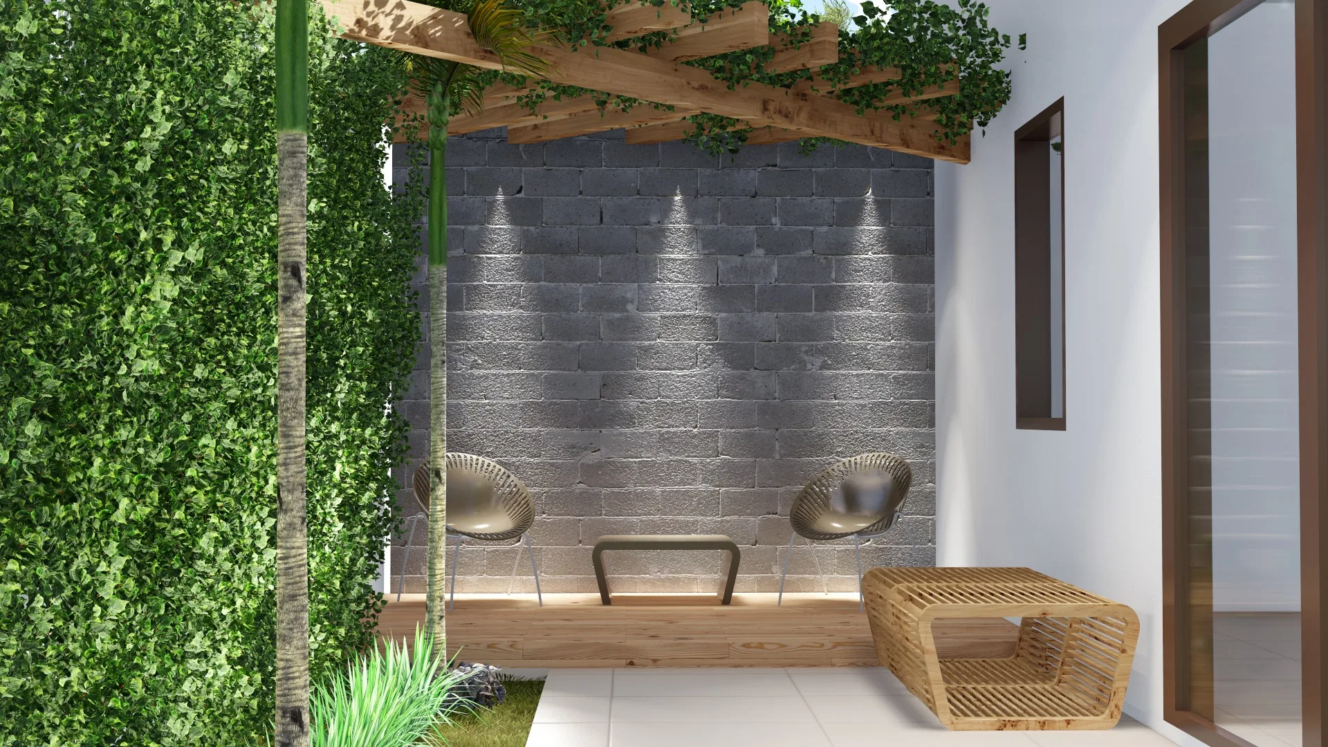 Estar externo sob pergolado com muro de bloco aparente iluminado por spots embutidos, duas poltronas trançadas e mesa de vime junto a cerca-viva densa.