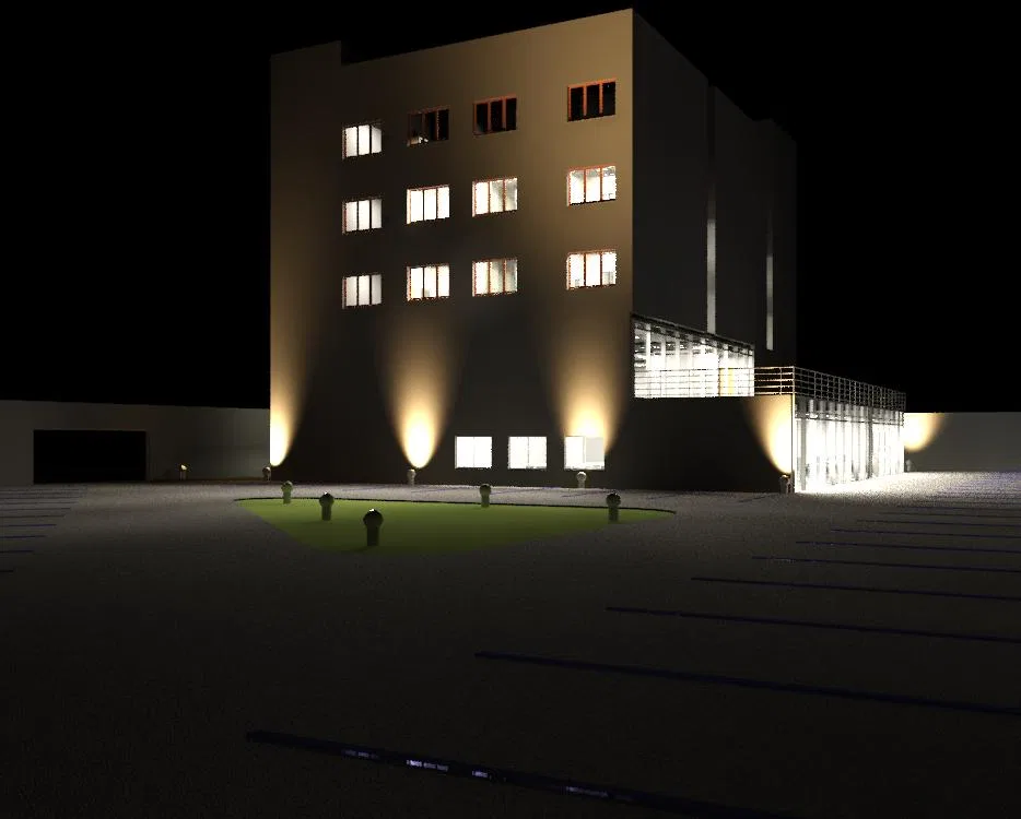 Fachada noturna de edifício de vários pavimentos com janelas iluminadas, refletores de base, anexo envidraçado à direita e estacionamento em primeiro plano