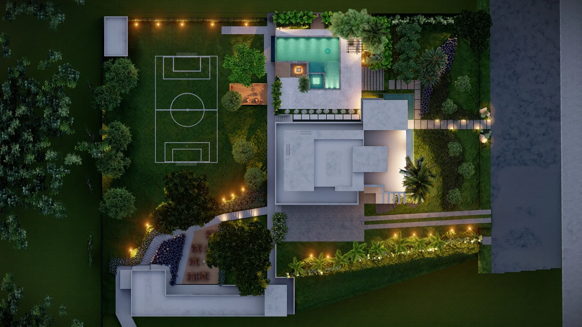 Vista aérea vertical do lote mostrando quadra esportiva, piscina, caminhos de pedra e jardins iluminados à noite